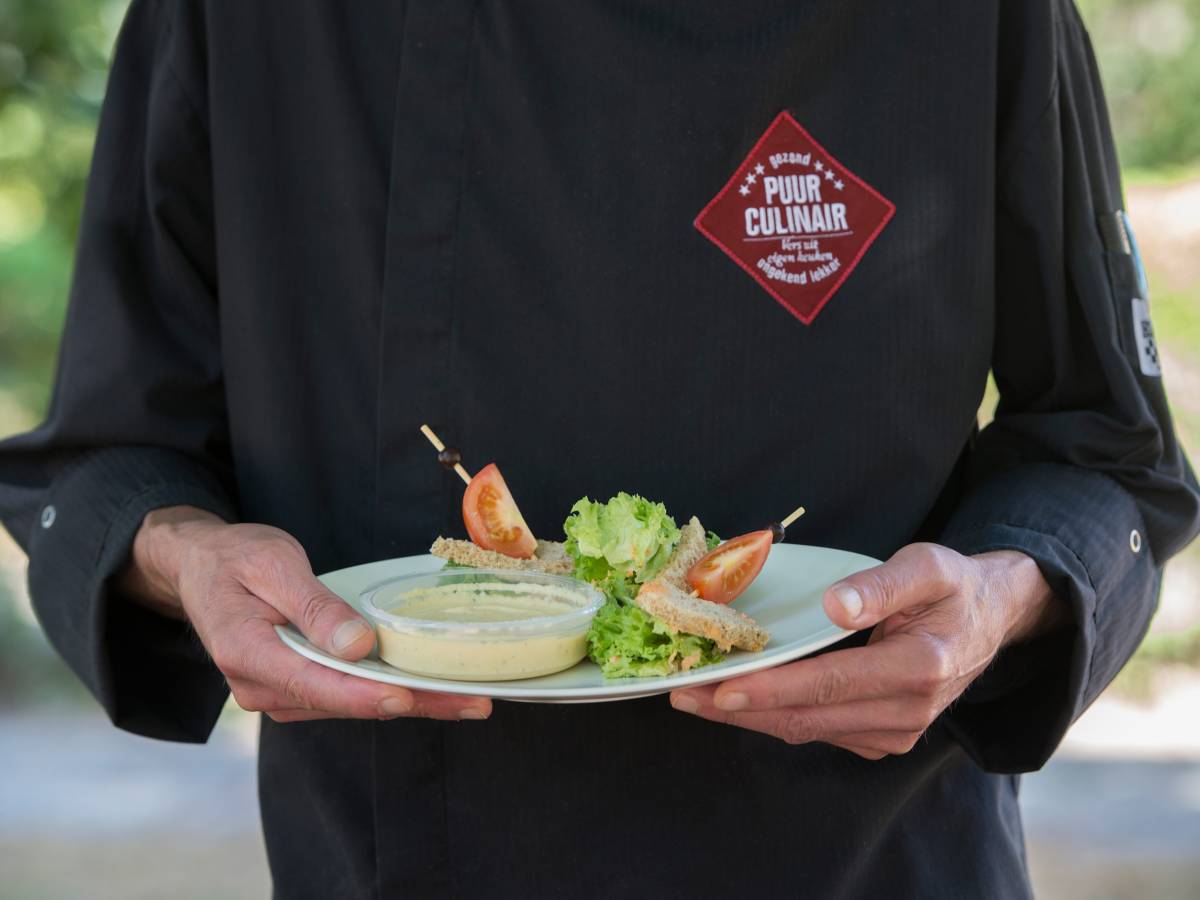 man houdt bord vast met eten